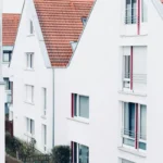 Kawasan perumahan modern dengan rumah-rumah bercat putih beratap merah dalam kompleks properti